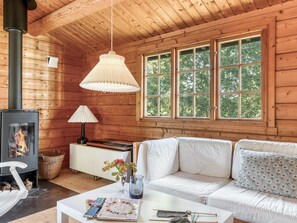 A cozy cabin interior with a fireplace, white sofa, and large windows. - "Sigref" - 4km from the sea by Interhome (Ålbæk)