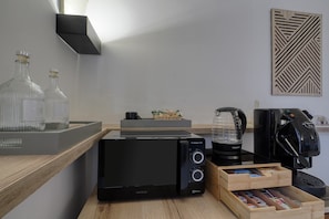 Een moderne keuken met een ProClean 3300 magnetron, een koffiezetapparaat en een lade vol koffiepads.