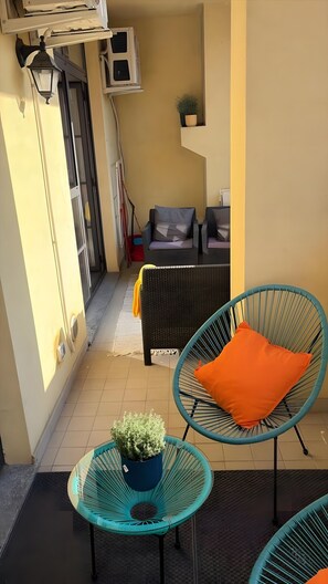 A narrow outdoor corridor with a potted plant, two wicker chairs with cushions, and a small table. - Apartment 'La Casa Di Sole' with Private Terrace, Wi-Fi and Air Conditioning (Milan)