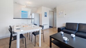 Un espacio moderno para vivir con comedor, un sofá de cuero negro y una mesa de centro.