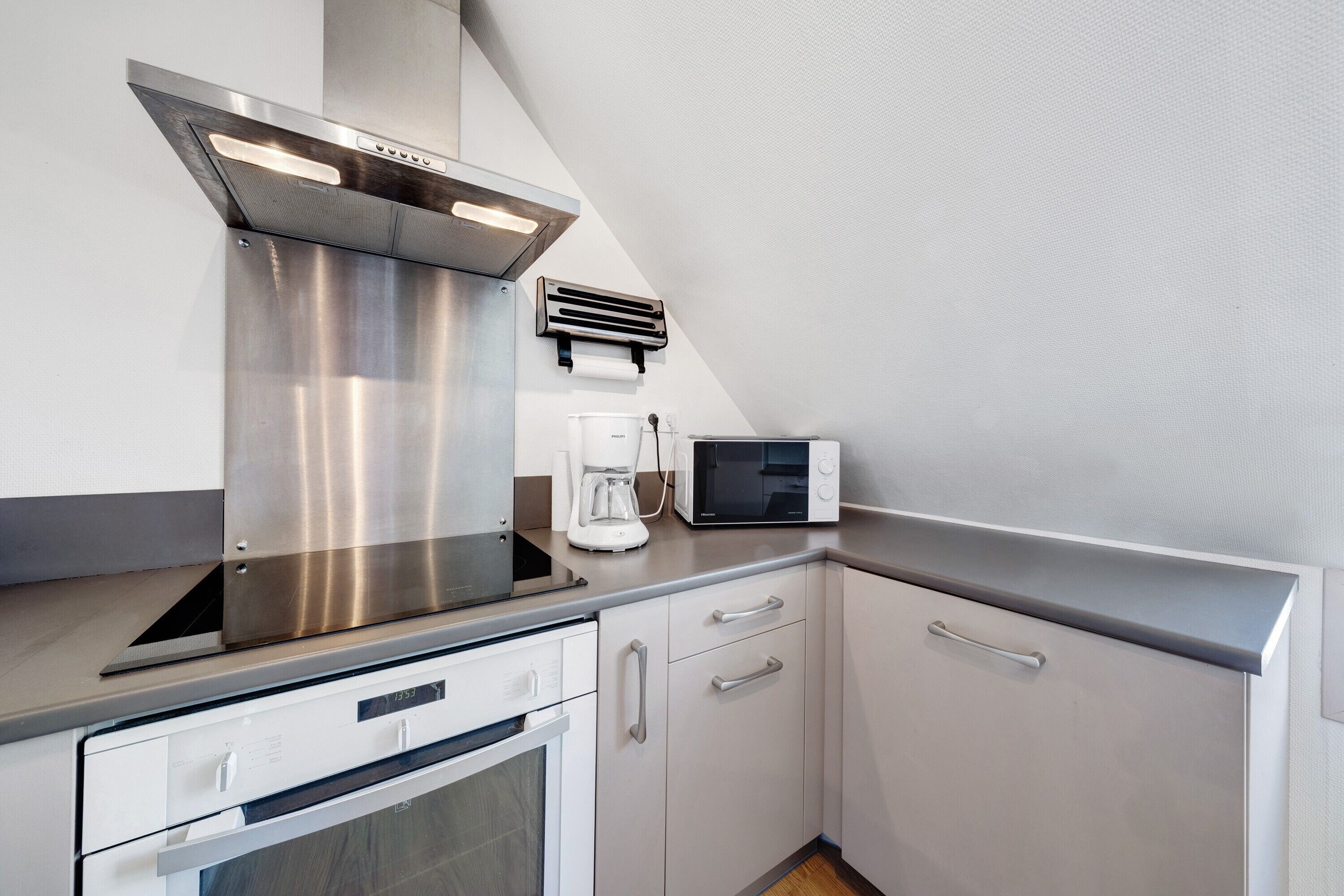 A kitchen with stainless steel appliances, a microwave, and a coffee maker.