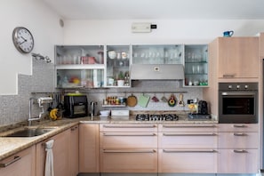 A kitchen with a sink, stove, microwave, and cabinets.