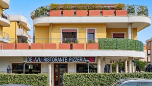 Un edificio a più piani con una pizzeria chiamata 'De'Avu Ristorante Pizzeria' al piano terra.