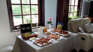 A breakfast buffet with pastries, bread, and fruit on a table near a window with curtains. - Guest Room “Le Manoir Du Tertre - Room 2” with Terrace, Garden and Wi-Fi (Saint-Josse)
