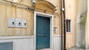 A building with a green door, electrical boxes, and a metal vent. - Apartment 'La Casa Di Giorgia' with Wi-Fi and Air Conditioning (Chioggia)
