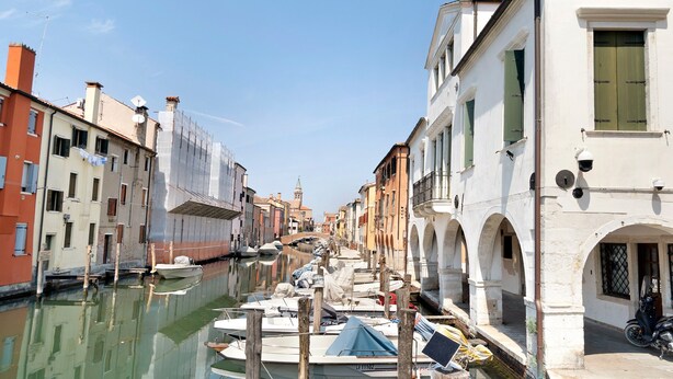 A canal with boats docked, buildings with arches, and a clear sky. - Apartment 'La Casa Di Giorgia' with Wi-Fi and Air Conditioning (Chioggia)