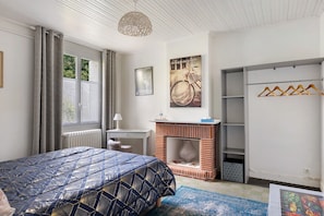 Ein Schlafzimmer mit Bett, Schreibtisch, Kamin und Kleiderschrank.