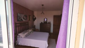 Un dormitorio con cama, cómoda, espejo y ventilador de techo.