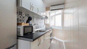 Une cuisine moderne équipée d’un four à micro-ondes, d’un évier et d’un crédence décorée.