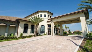 A large building with a covered entrance and a paved driveway. - Modern Championsgate Pool Villa Waterparks! Disney. 616 (Kissimmee)