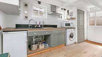 A compact kitchen with a sink, microwave, and washing machine.