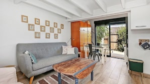 Een woonkamer met een bank, salontafel en ingelijste foto's aan de muur.