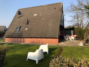 Ein Haus mit geneigtem Dach, einer Satellitenschüssel und einem kleinen Fenster.