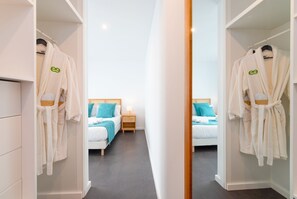 Una habitación de hotel con una cama, mesitas de noche y un espejo que refleja el espacio.
