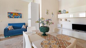 A modern living room with a sofa, coffee table, TV, and decorative items.