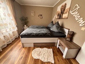Une chambre à coucher avec un lit, des tables de chevet, un tapis et des éléments de décoration murale.