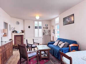 Una sala de estar acogedora con chimenea, una mesa de comedor y un sofá.