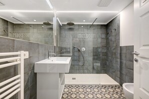 Ein modernes Badezimmer mit Dusche, Waschbecken und Toilette.