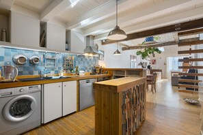 A modern kitchen with a built-in washing machine, wooden countertops, and a variety of kitchen utensils. - “At the Foot of the Market” La Rochelle, City Center (La Rochelle)