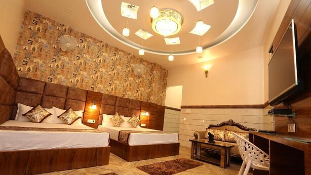 Habitación de hotel con dos camas, televisión, escritorio y pared con diseño.