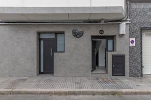 Ein Gebäude mit grauer Fassade, einer schwarzen Tür und einem Schild mit der Aufschrift 'Camacho Cantina'.