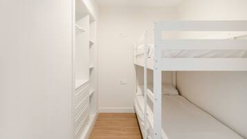 A bunk bed room with a wooden floor and white walls.