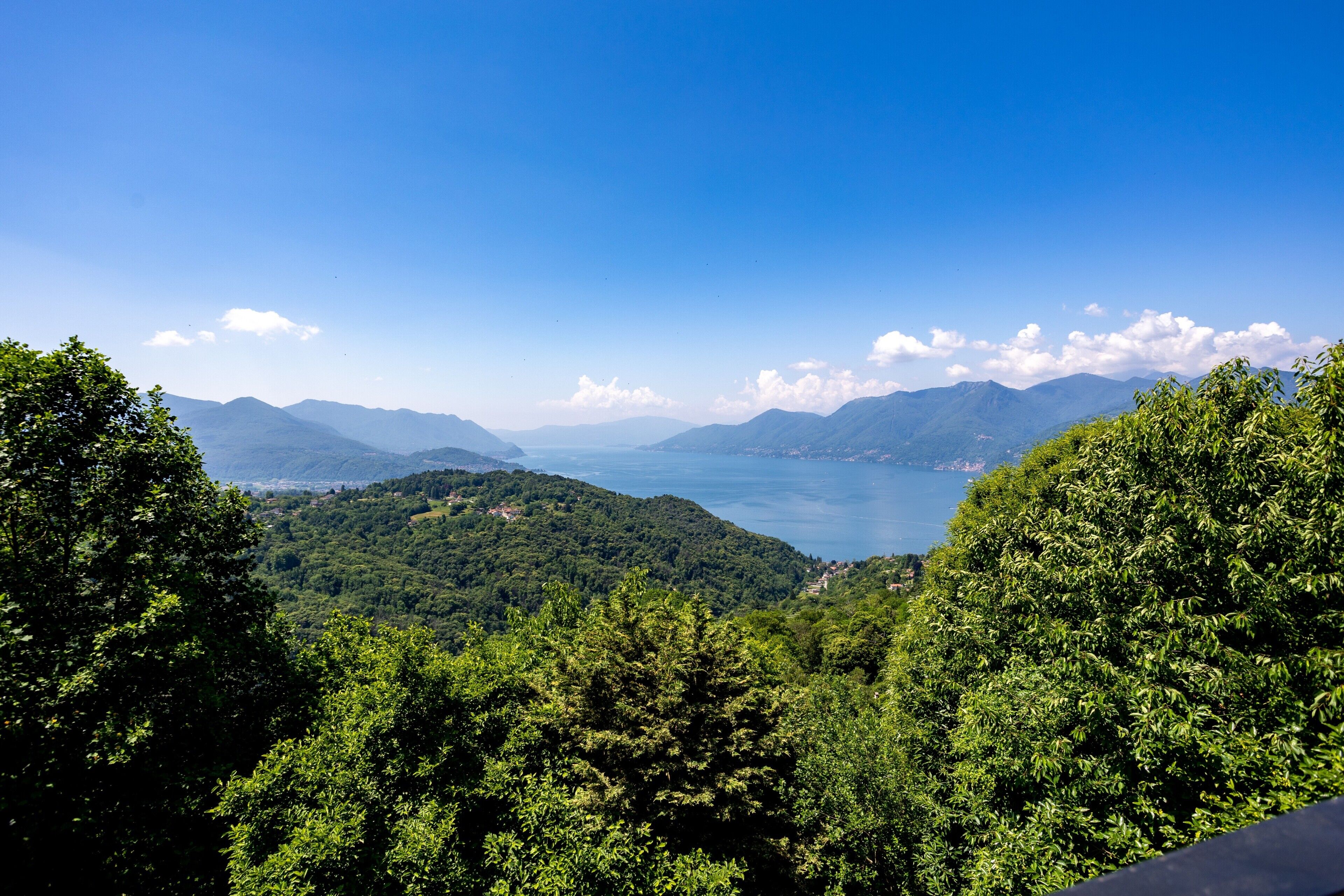 Un paisaje montañoso con abundante vegetación verde y un cielo azul despejado.