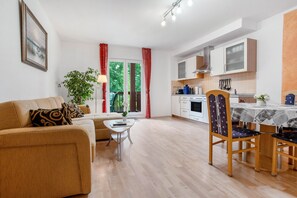 Ein modernes Wohnzimmer mit Sofa, Couchtisch und Essbereich mit Stühlen.