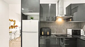 A modern kitchen with a refrigerator, microwave, and toaster. - Holiday Home 'Lobo's House' with Sea View, Private Terrace and Wi-Fi (Câmara de Lobos)