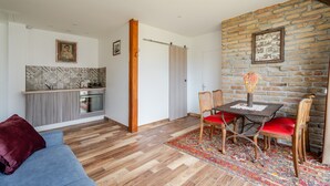 A modern kitchen with a built-in oven and a dining area with a table and chairs.