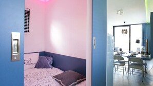 A bedroom with a bed, a desk, and a chair.