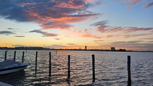 A waterfront view with a dock and a boat. - Dosana Blu Studio 'Aqua Alta' with Wi-Fi and Air Conditioning (Chioggia)