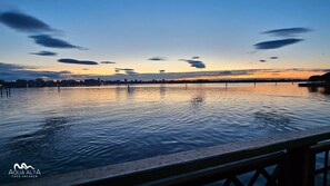 Ruhiges Ufer mit klarem Himmel und weiter Skyline der Stadt im Hintergrund.