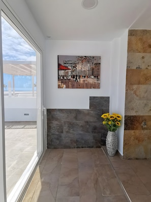 Ein Zimmer mit einem großen Fenster, einem Kamin und einer Vase mit Blumen.