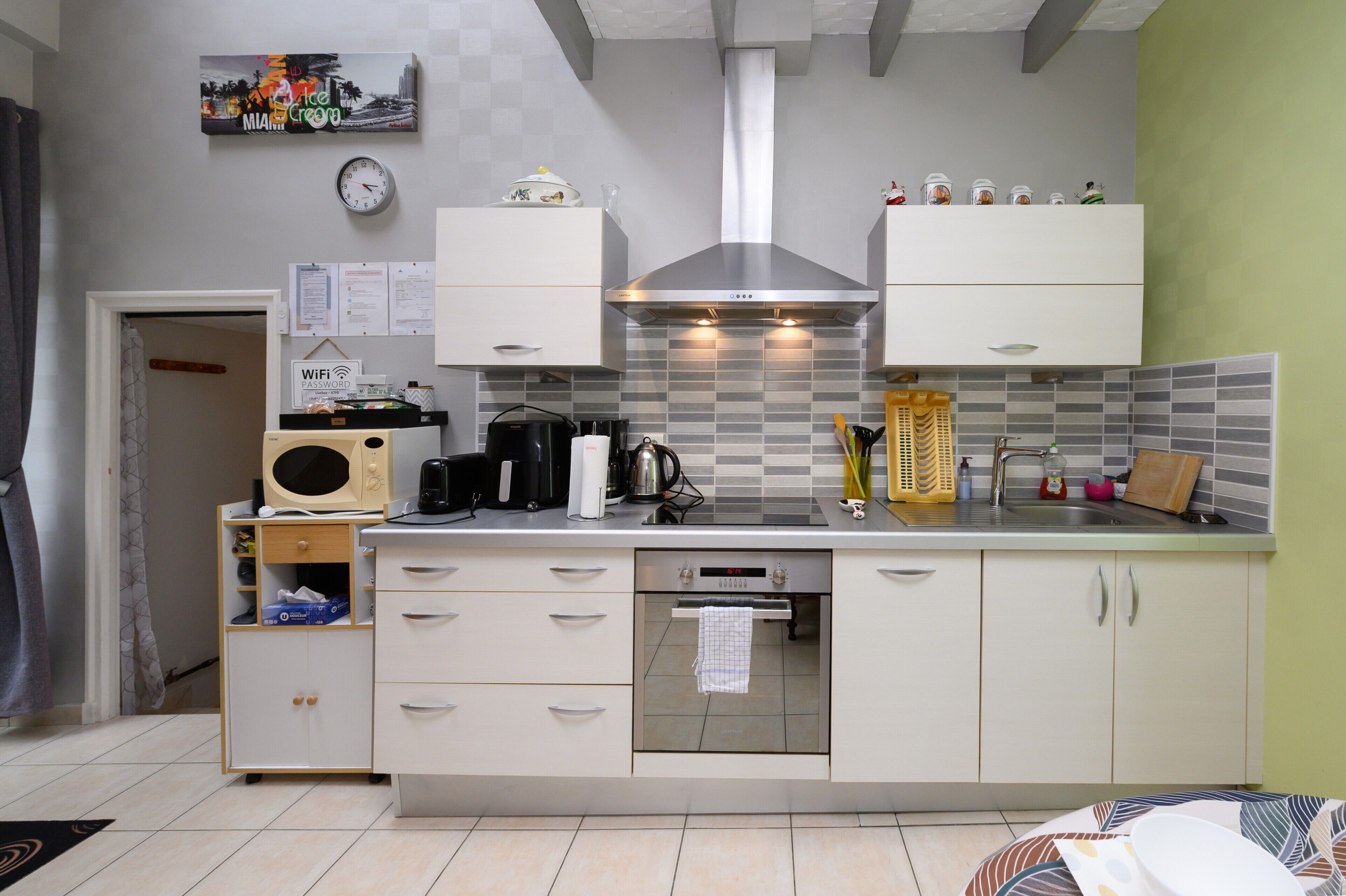 A compact kitchen with a microwave, coffee maker, and a built-in oven.