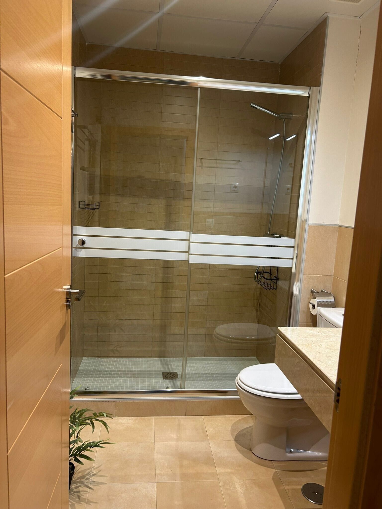 Ein modernes Badezimmer mit einer Duschkabine, einer Toilette und einem Waschbecken.