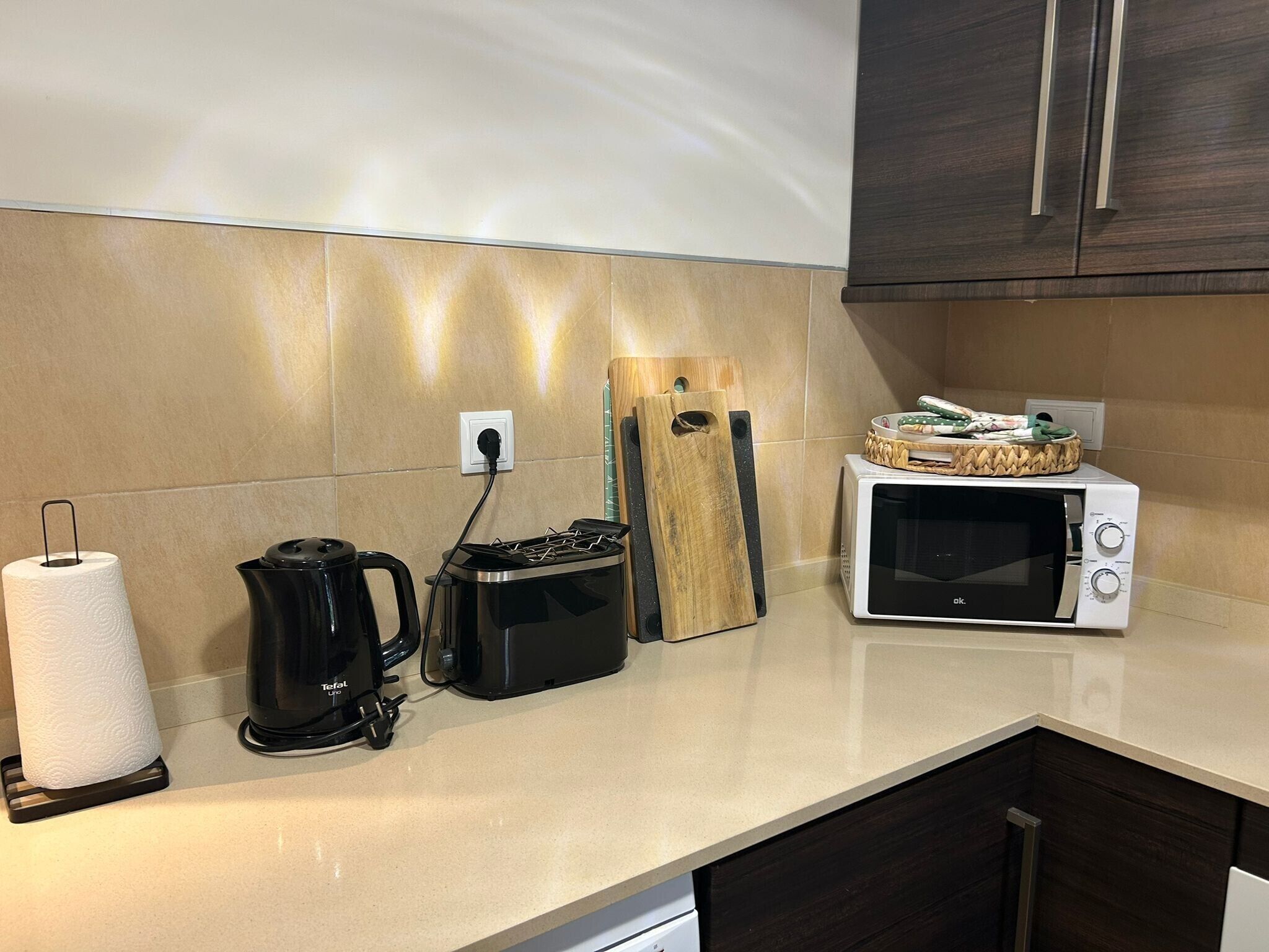 A kitchen with a microwave, a coffee maker, and a kettle.