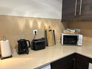 A kitchen with a microwave, a coffee maker, and a kettle. - Apartment 'Sol' with Private Pool, Wi-Fi and Air Conditioning (Fuente Álamo de Murcia)