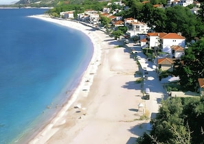 Eine Küstenstadt mit sandigem Strand, weißen Gebäuden und blauem Meer.