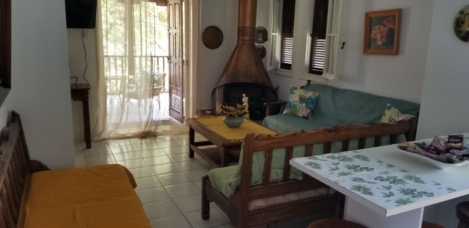 Una sala de estar acogedora con chimenea, un sofá, una mesa de comedor y un televisor.