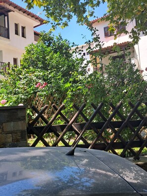 A courtyard with a wooden fence, a stone wall, and a building with a tiled roof.