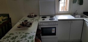 A kitchen with a stove, oven, sink, and a window. - Paradise in Ai Giannis Apartment with Sea View, Wi-Fi, and Air Conditioning (Agios Ioannis)