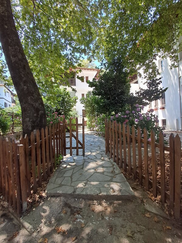 A stone pathway leading to a building with a wooden fence on both sides.