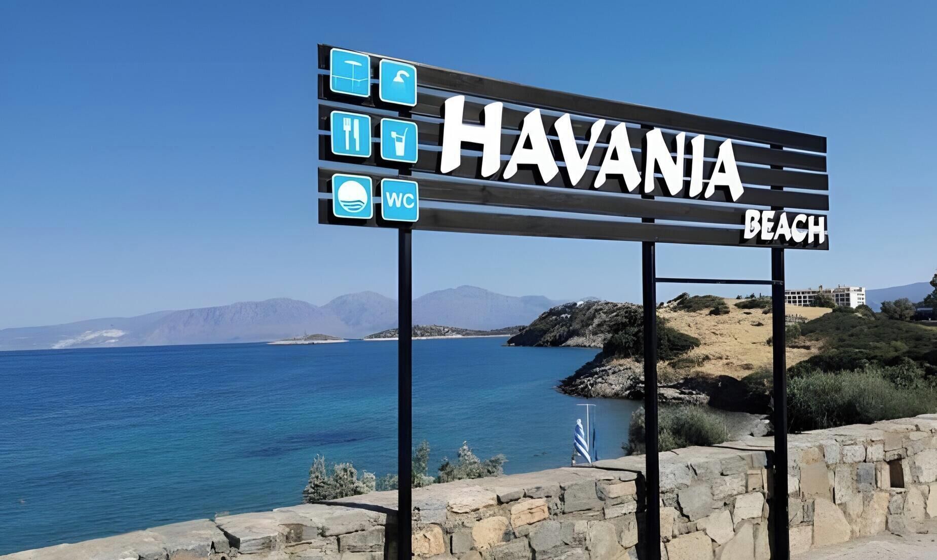 Placa para Praia Havania com ícones de praia, restaurante e WC.
