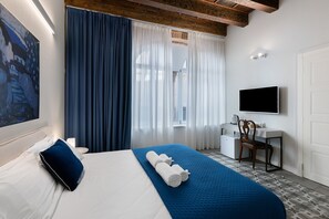 A hotel room with a bed, a desk, a chair, a TV, and a painting on the wall. - Room 'Stanza S21' with Wi-Fi and Air Conditioning (Verona)