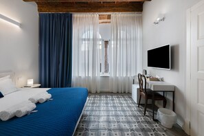 A hotel room with a bed, a desk, a chair, a TV, and a window with curtains. - Room 'Stanza S21' with Wi-Fi and Air Conditioning (Verona)