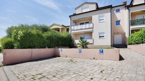 A paved courtyard with a brick pattern, surrounded by a low wall and greenery. - Holiday Home 'Seaview Apartment Poreć Umgebung' with Sea View and Air Conditioning (Tar)