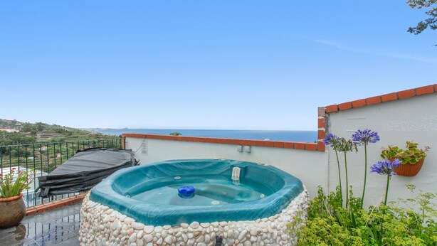 A hot tub surrounded by pebbles, a potted plant, and a view of the sea. - Apartment 'Pool  View' with Shared Pool, Shared Garden and Wi-Fi (Gaula)