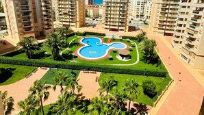 Zona residencial con edificios altos, piscina central y zonas verdes cuidadas.