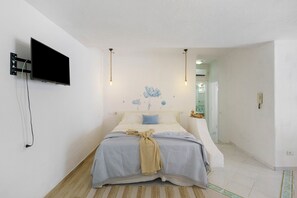 A bedroom with a bed, a mounted TV, and a wall-mounted light fixture. - Holiday Home 'Casa Gio e Angy' with Sea View, Wi-Fi & Air Conditioning (Forio)